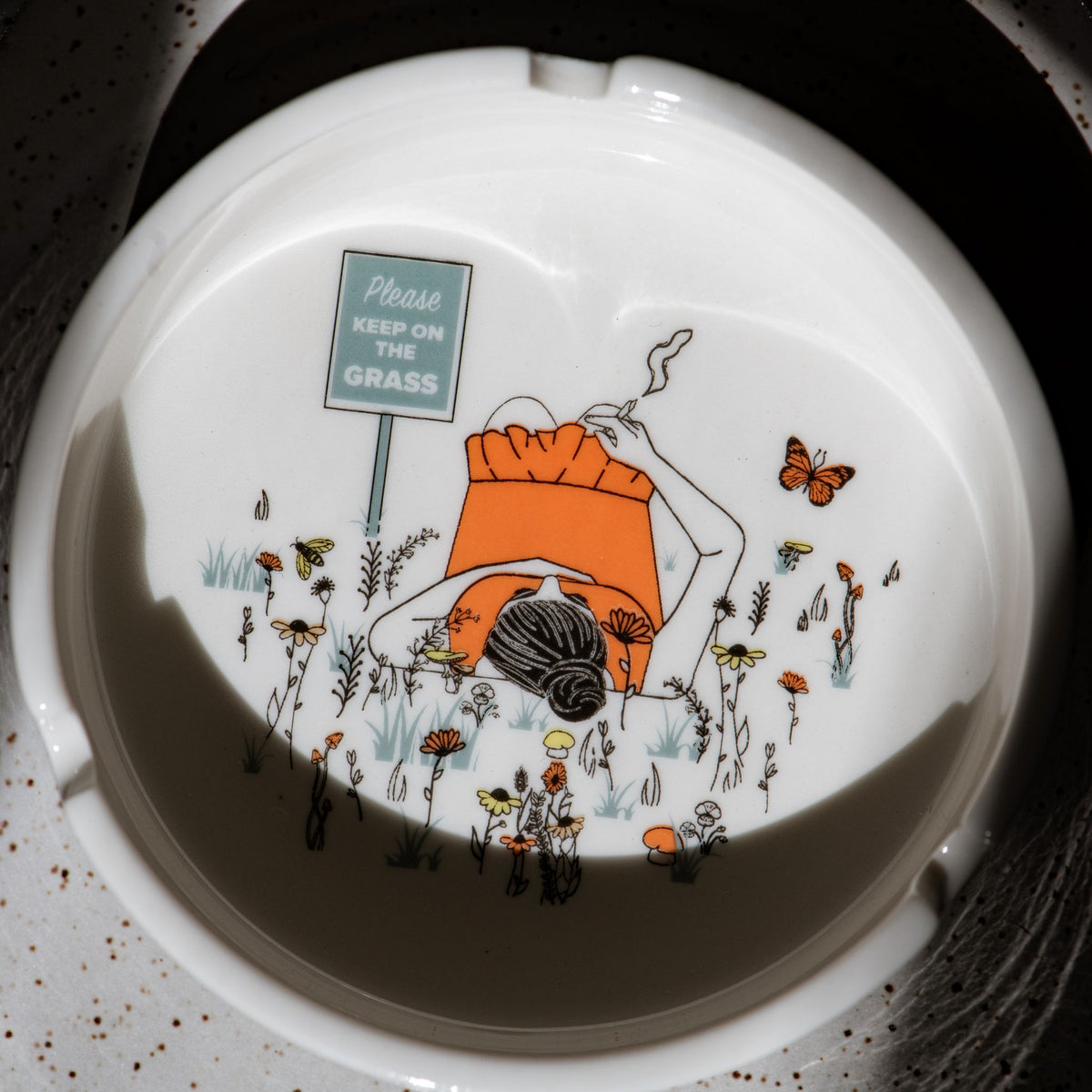 White porcelain ashtray with intricate detail and deep basin; designed to hold ash securely while adding a touch of humor and style to your coffee table decor.