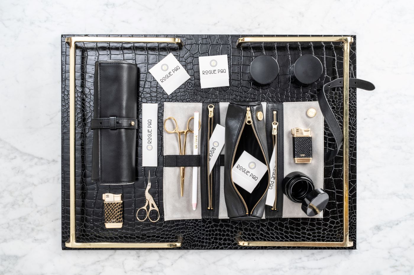 Rogue Paq Full Ritual Cannabis Gift Set in black leather organized on a leather valet tray; featuring a curated collection of gold-tone tools, UV glass storage jars, and a scent-suppressant stash bag for the ultimate elevated experience.